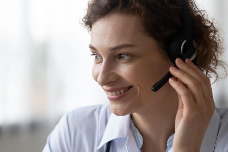 Arzttermin Hotline: Frau telefoniert mit Headset